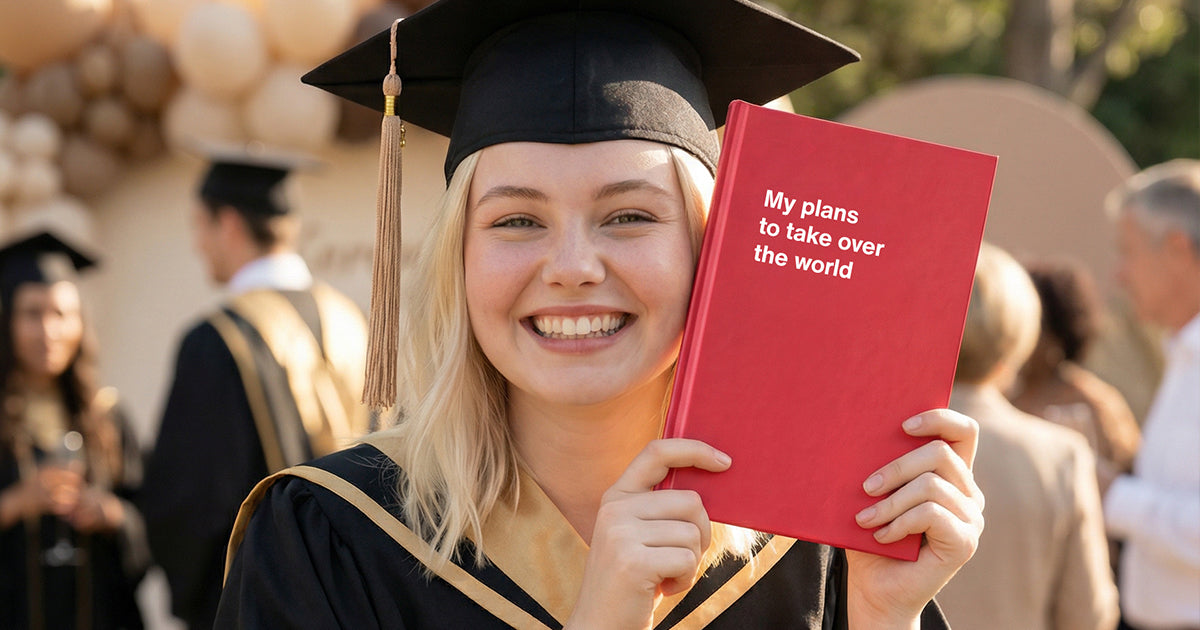 A happy graduate celebrating with her funny graduation gift WTF Notebooks