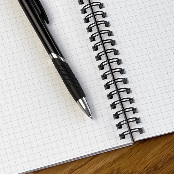 A close-up image of a WTF Notebook's gridded inside pages.